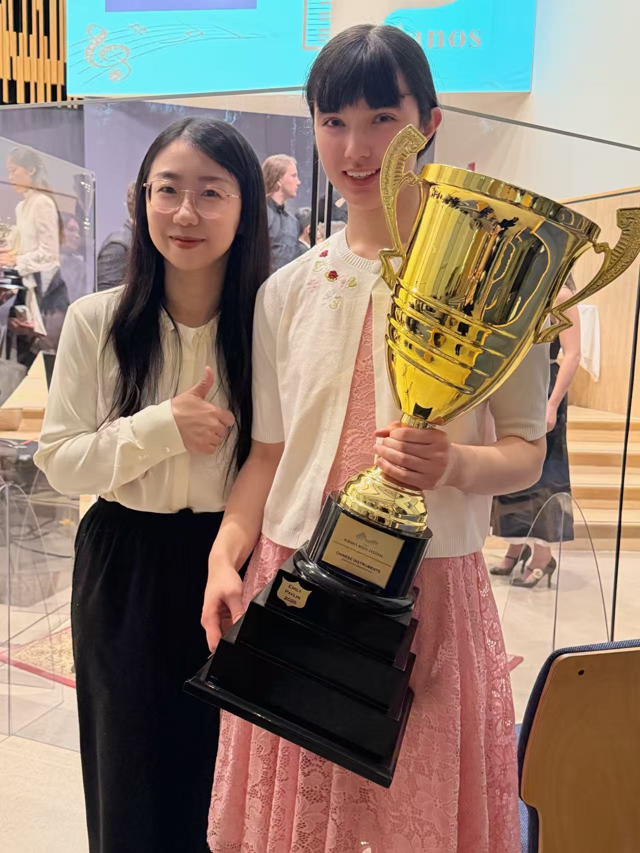 Li Zhang and student Emily with an award trophy