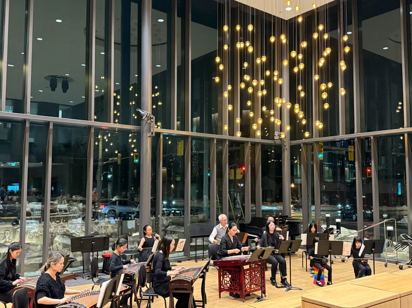 Chinese instrument ensemble performing in a warmly lit concert space