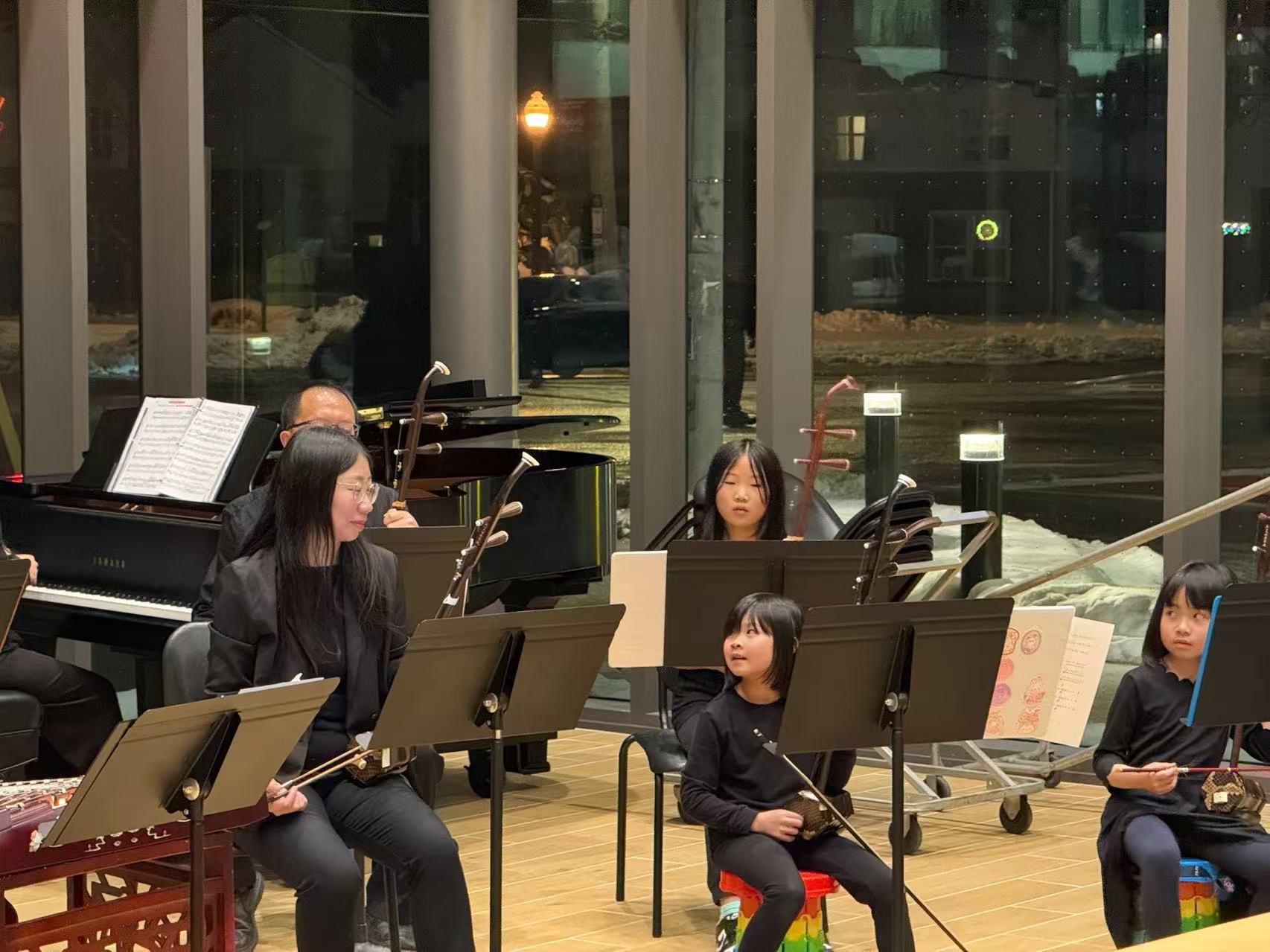 Erhu musicians of different ages seated with their instruments