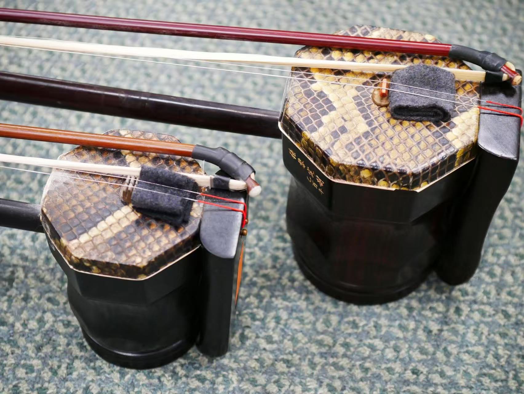 Close-up photograph of two erhu instruments and their bows