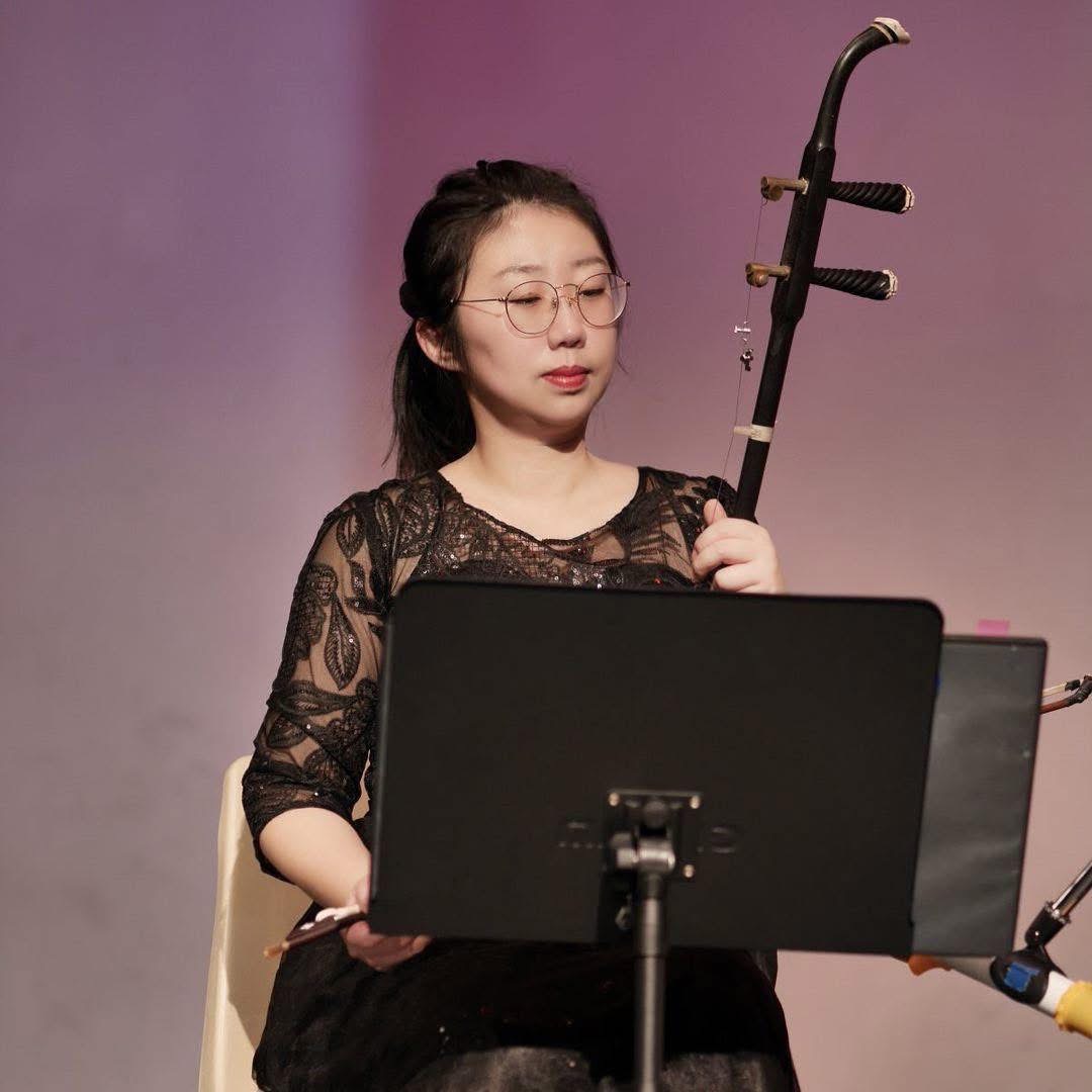 Li Zhang holding an erhu on stage